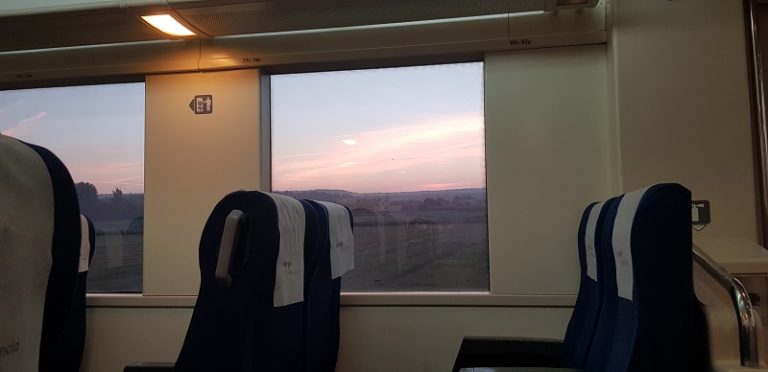 imagen de varios asientos en un vagón de tren con la ventanilla de fondo- turismo